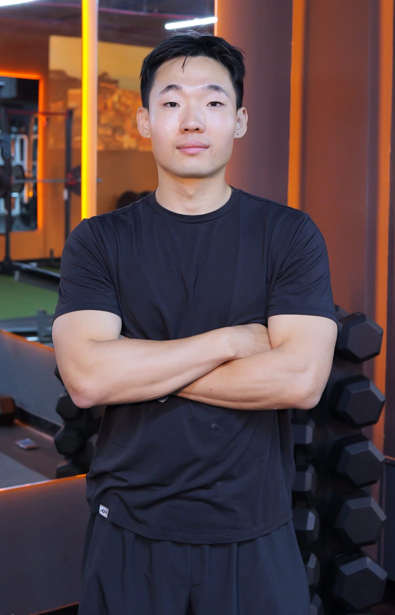 Drew, personal trainer, arms crossed in the gym